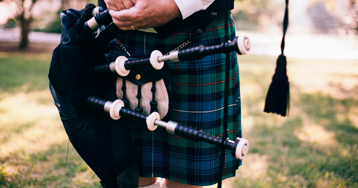 Bagpiper in kilt holding bagpipes. Image Source: https://pixabay.com/photos/bagpipe-scot-uilleann-pipes-349717/