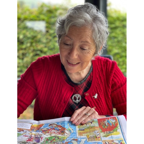 woman in red cardigan reading a map